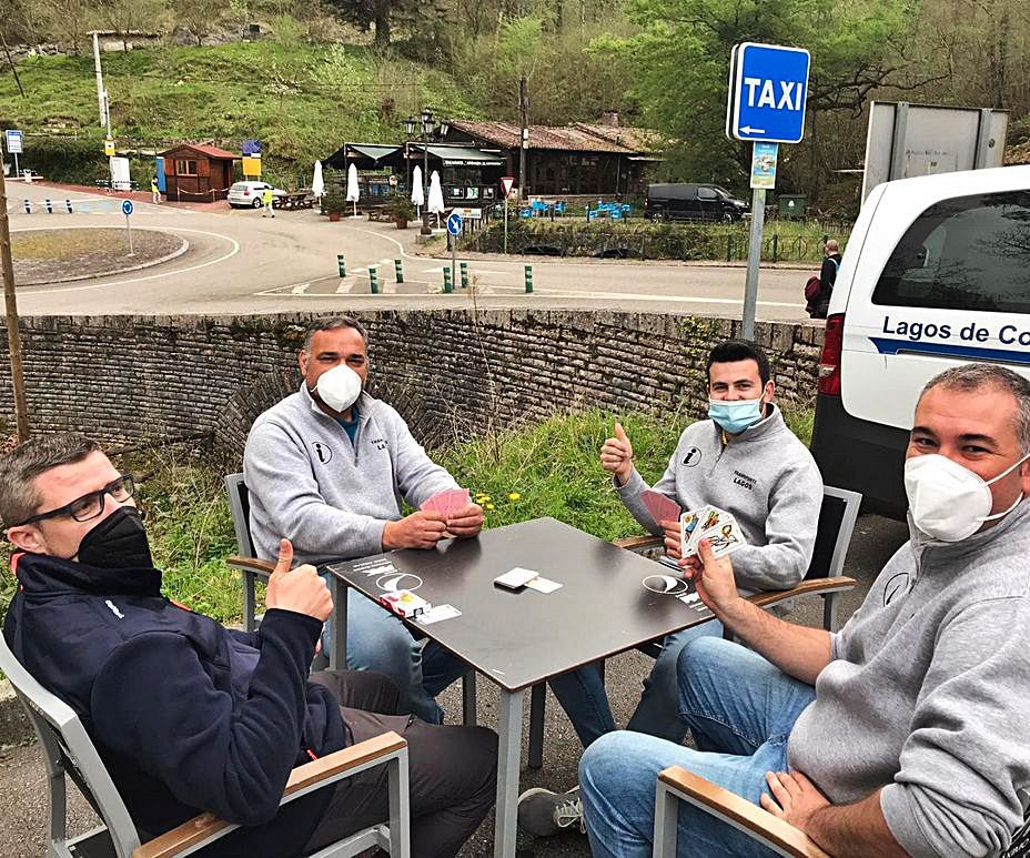 Por la izquierda, los taxistas Alberto González, José Sánchez, Luis de la Vega  y Francisco García, el jueves, jugando a las cartas en Covadonga. | J. M. C.