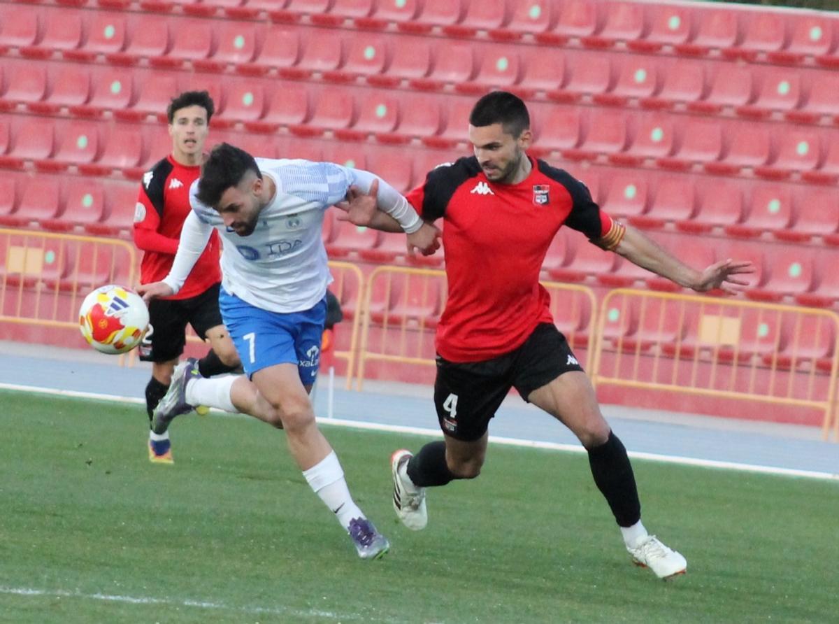 El artillero David Megina pugna un balón junto al futbolista local Pablo Morgado.