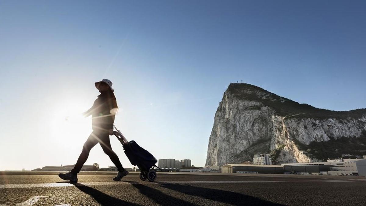 Una mujer camina por el lado español de la frontera entre España y Gibraltar, con el Peñón al fondo, en La línea de la Concepción, el 1 de marzo.