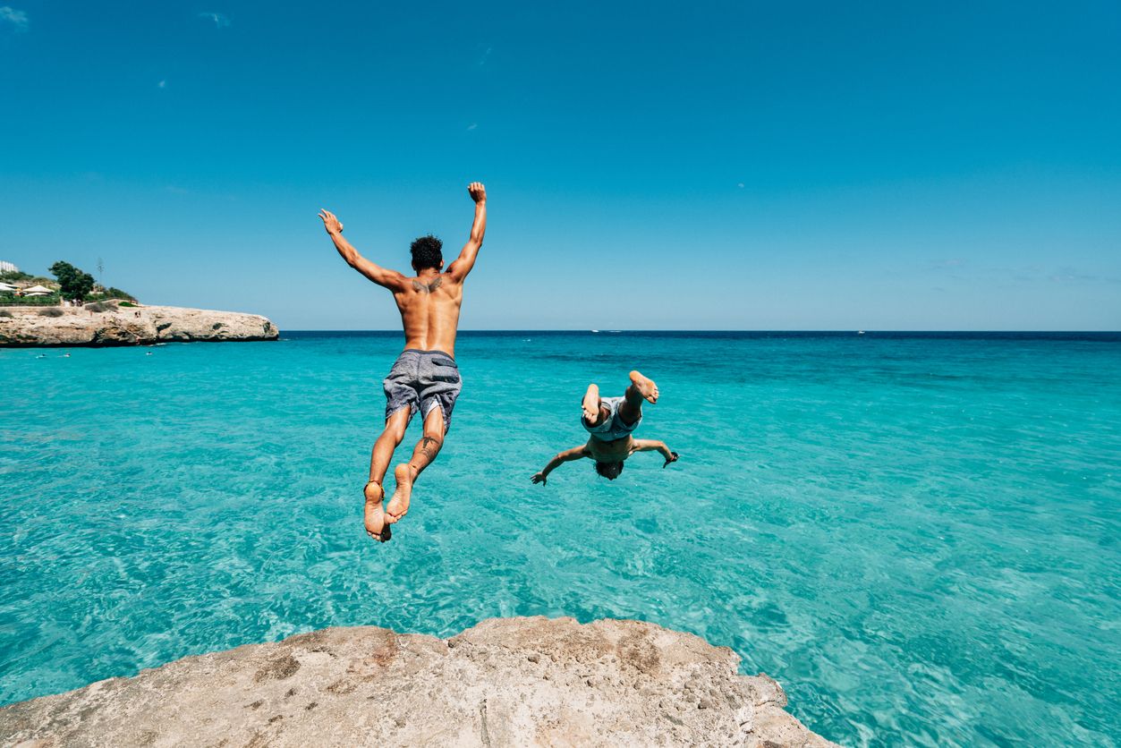 Dos amigos disfrutando en una playa paradisiaca.