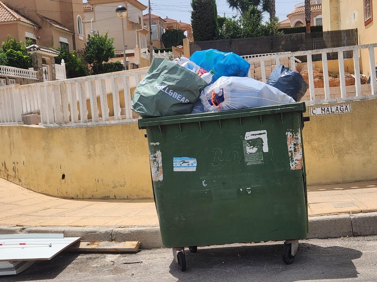 Así están los contenedores de basura de San Miguel de Salinas: hasta arriba de podas y enseres sin que Actúa los retire