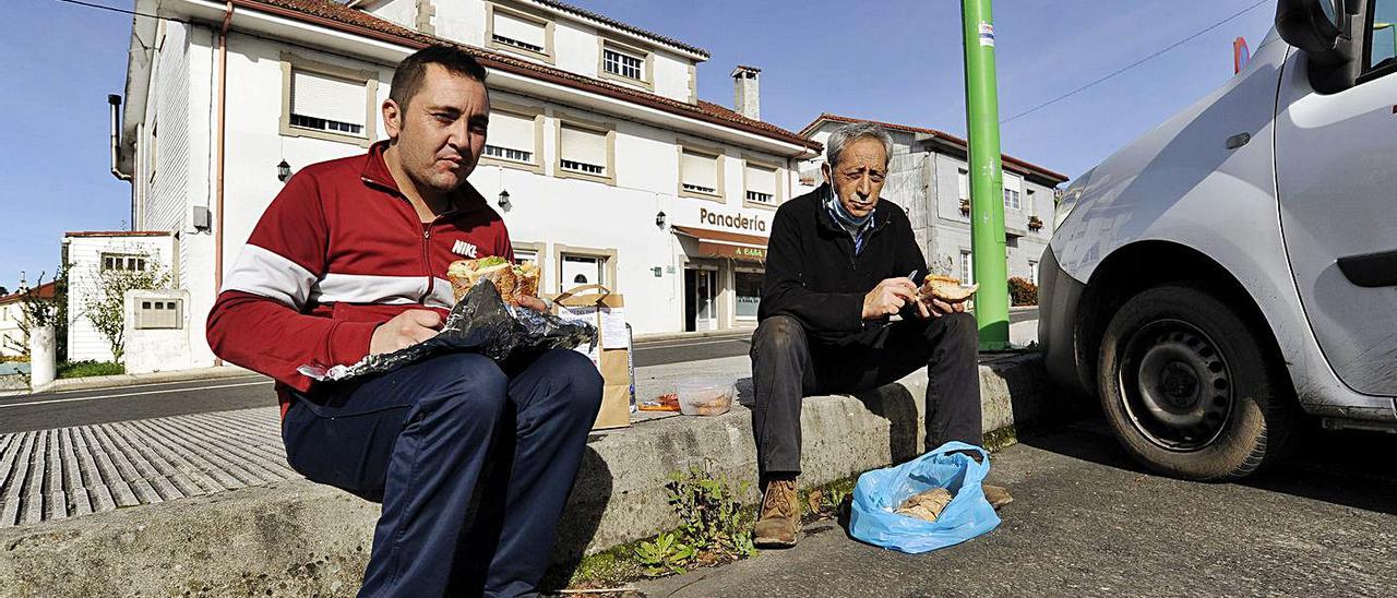 Dos clientes saborean un almuerzo sobre la acera, al pie de la N-640 en Liñares.  | // BERNABÉ/JAVIER LALÍN