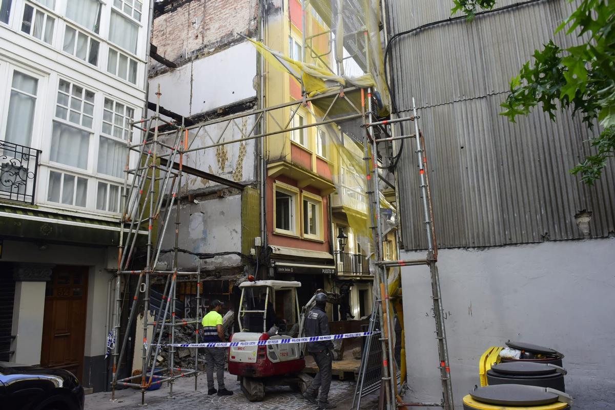 Precinto policial en la zona donde los operarios de la empresa de demolición retiran los restos y escombros.