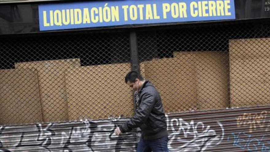 Un hombre camina cabizbajo por una calle española.