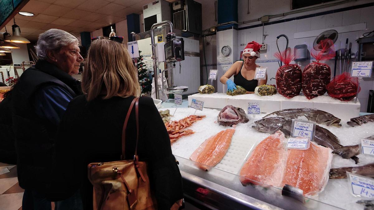Dos personas compran pescado en un puesto del Mercado de África.