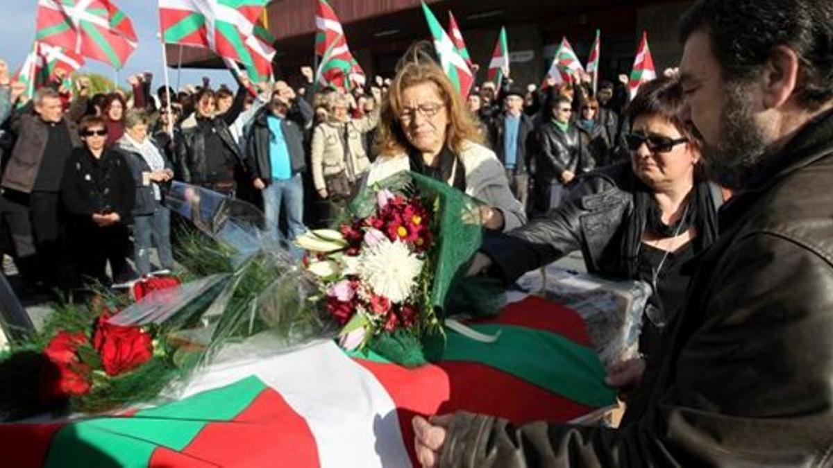 Familiares de 'Thierry' colocan flores sobre el féretro del exdirigente etarra, este viernes, a su llegada al aeropuerto de Sondika (Bilbao).