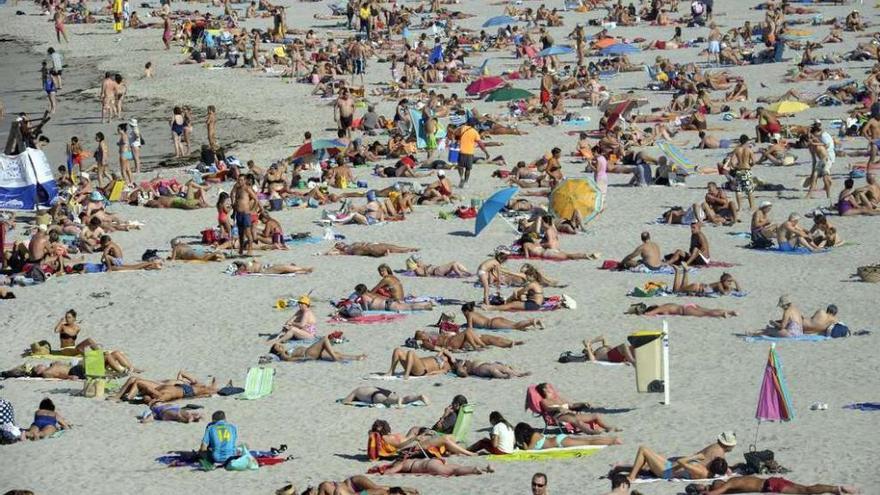 Cientos de bañistas, ayer, en la playa de Riazor. víctor echave