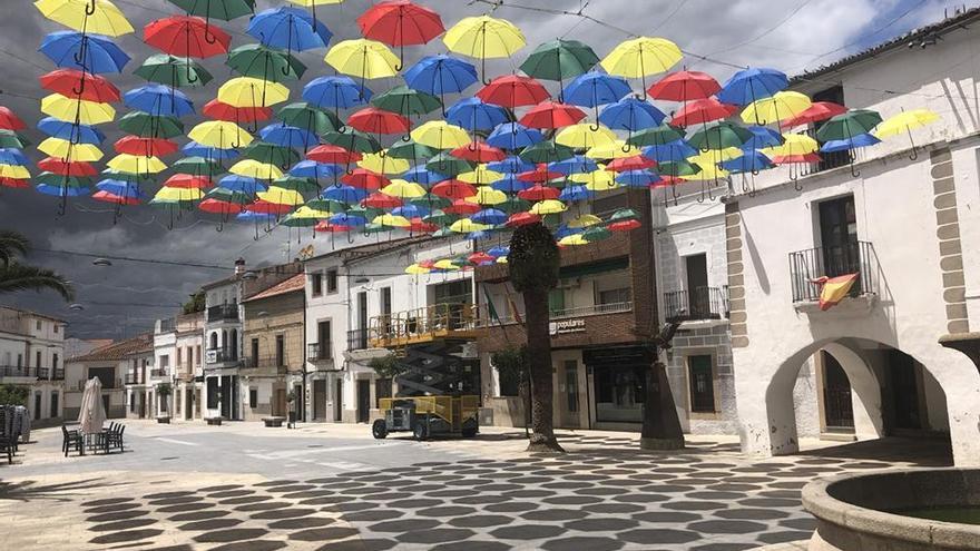 Comienzan a colocarse los paraguas de colores en la plaza Mayor de Malpartida de Cáceres