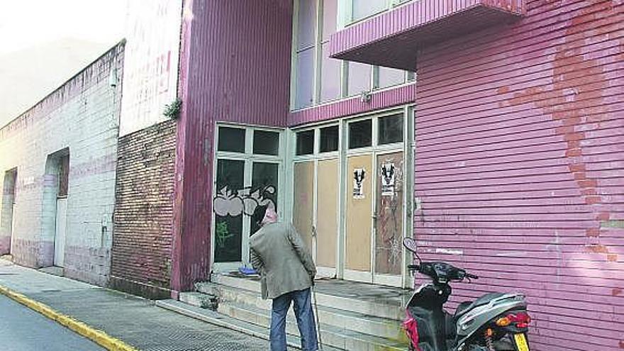 Un hombre observa el estado actual del antiguo cine Goya de Luarca.