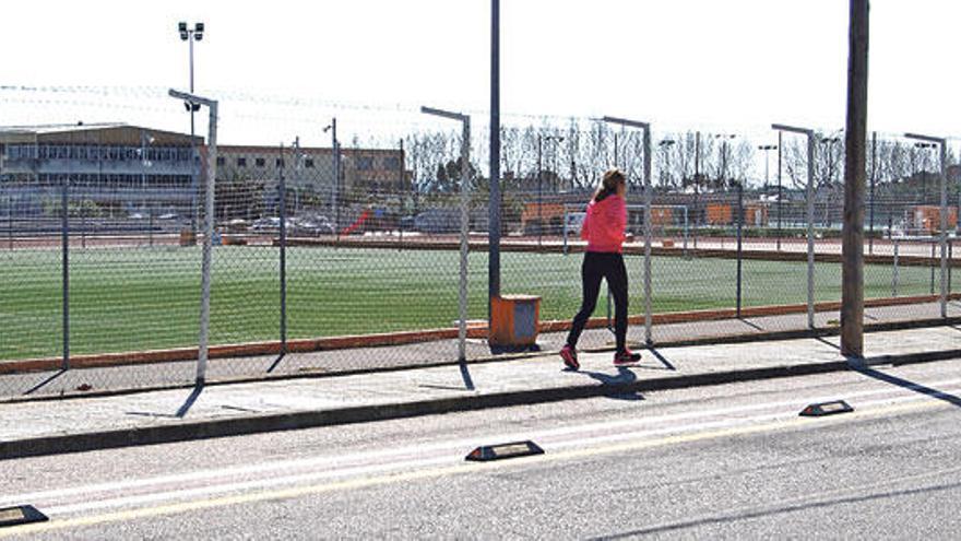 Una corredora pasa ante las instalaciones del Mateu Cañellas, equipadas con césped artificial