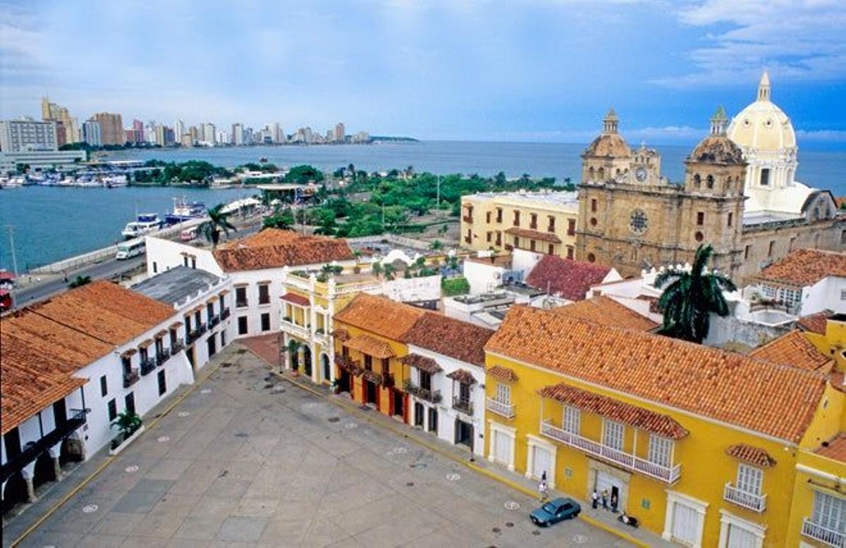 Plaza de la Aduana de Cartagena de Indias con la Iglesia de San Pedro Claver a la derecha y los edificios hoteleros de la zona de Bocagrande al fondo.