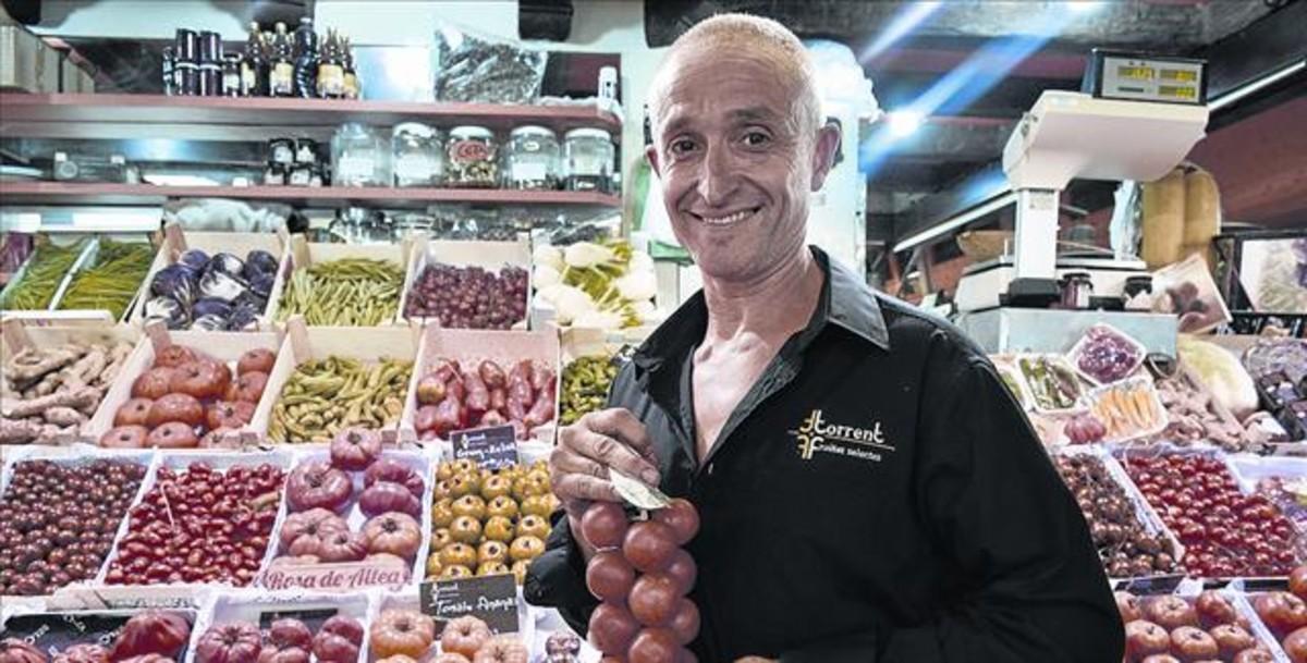 Juan Carlos Torrent, amb tomàquets per untar, a la seva parada del mercat de Santa Caterina.