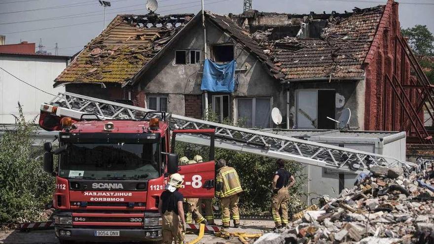 Bomberos ante la vivienda en la que se registró el incendio. // Efe