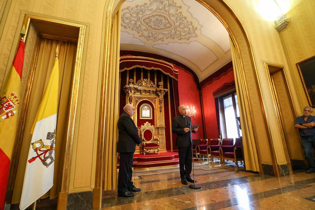 El opispo Ros, en el Salón del Trono del Palacio Arzobispal, anunciando su marcha a Santander ante el retrato del Papa y el arzobispo Benavent,