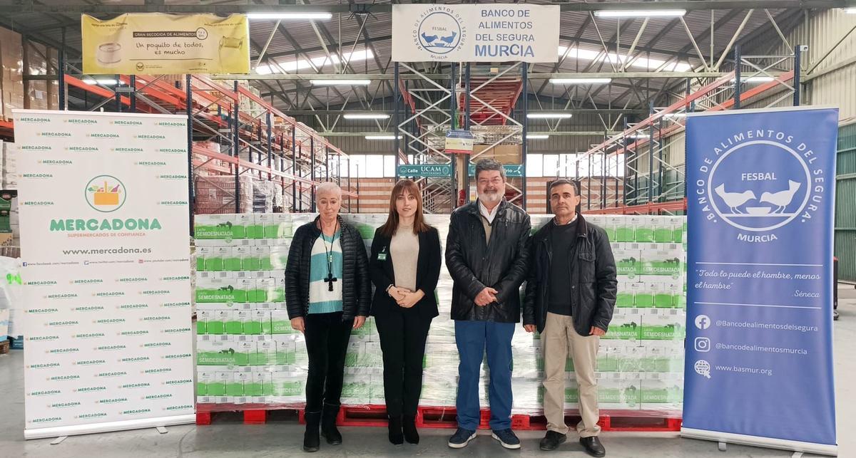 Esther Piornos de Mercadona y Jose García-Galbis, presidente del Banco de Alimentos, junto a otros miembros del mismo, en la entrega de los mas de 7.000 litros de leche donados por Mercadona