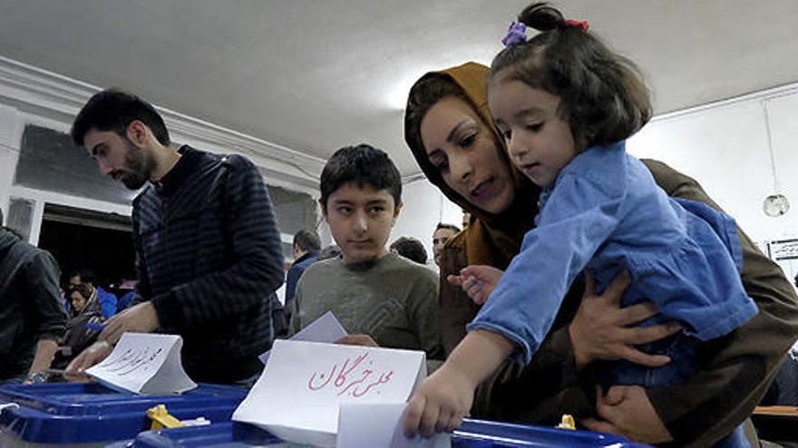 Una mujer vota con su hija en Teherán.