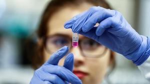 Una científica sostiene una muestra de una investigación sobre coronavirus.