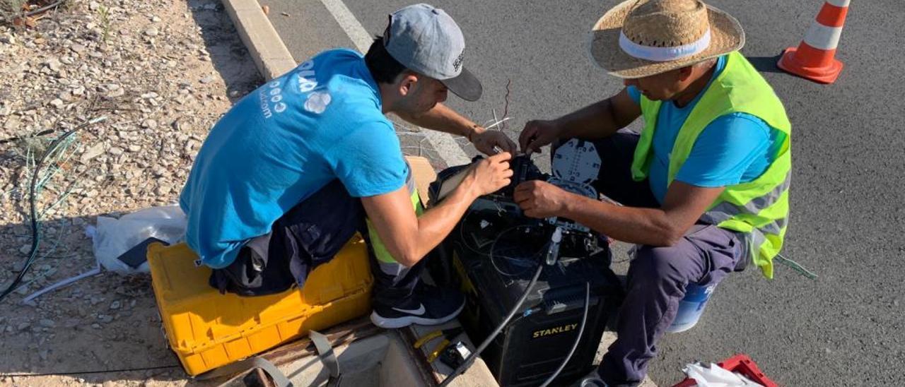 Dos operarios de la empresa de fibra arreglando el cableado.