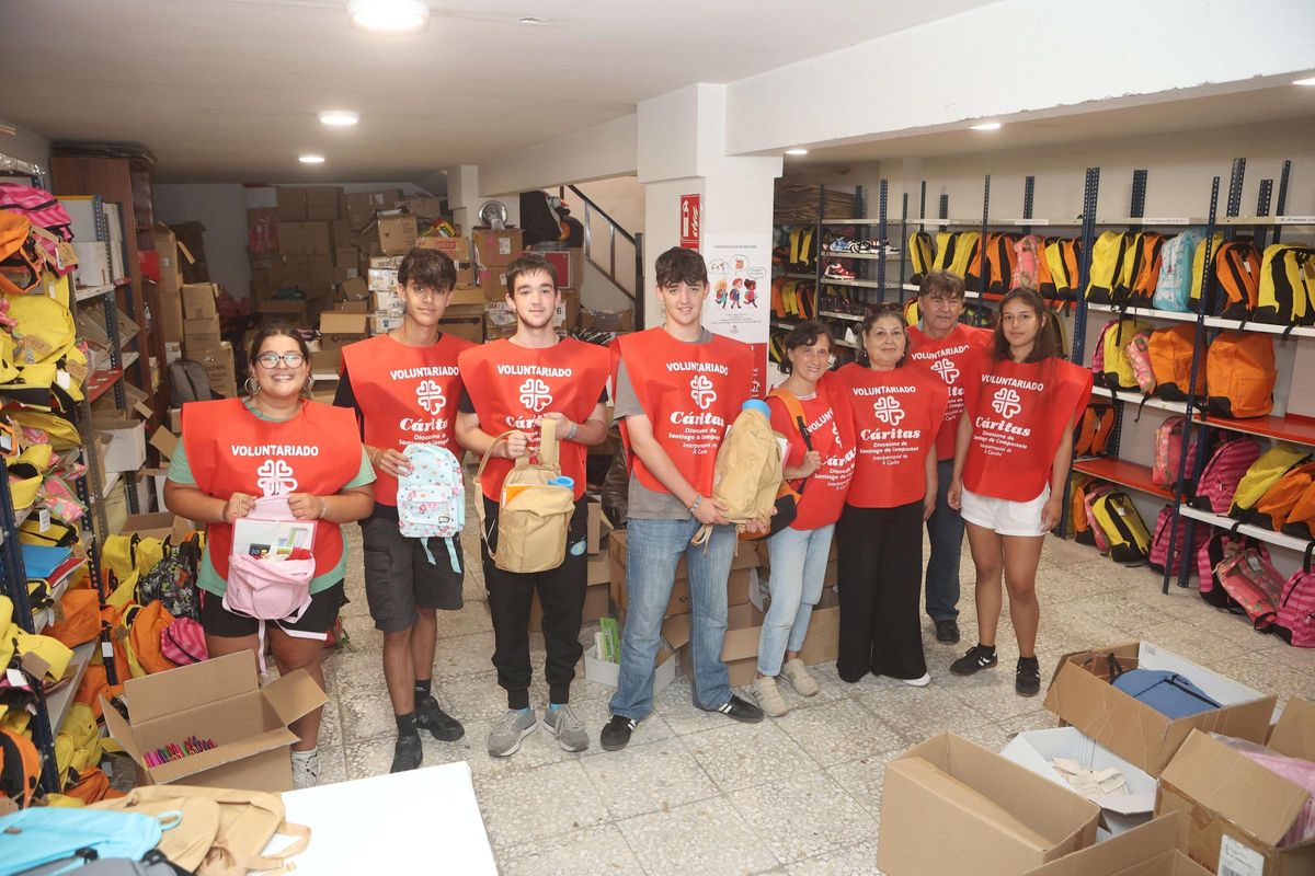 De izquierda a derecha, Sara Ansede, Iván Mariño, Adam y Lucas Huntingford, Ángeles Ferreño, Marta Lucía López, Benito Coiradas y Laura Rojas, ayer, en el local de Cáritas Interparroquial de la calle Pan de Soraluce, en Os Mallos.