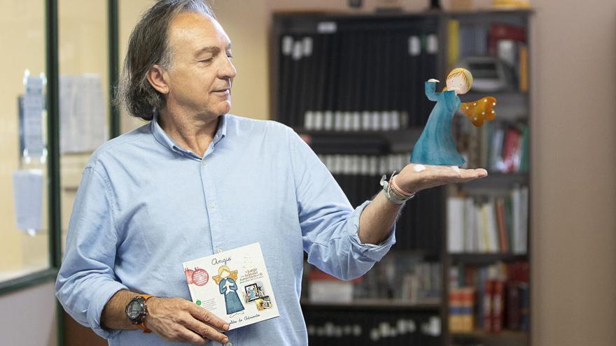 Vicente Miguel, con el libro calendario en una mano y, en la otra, el ángel virtual.