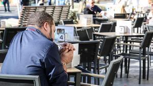 Un hombre fumando en una terraza de Alicante.