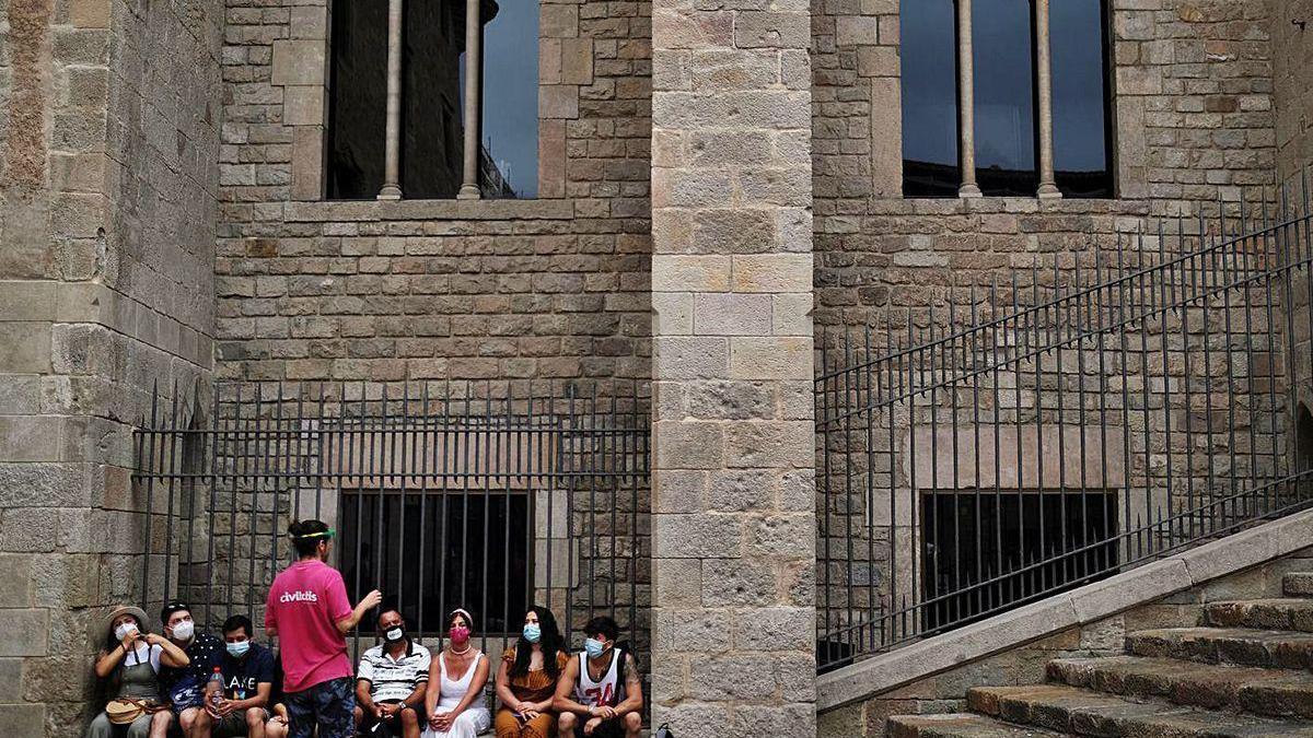 Un guía habla con un grupo de turistas en el Barrio Gótico de Barcelona.