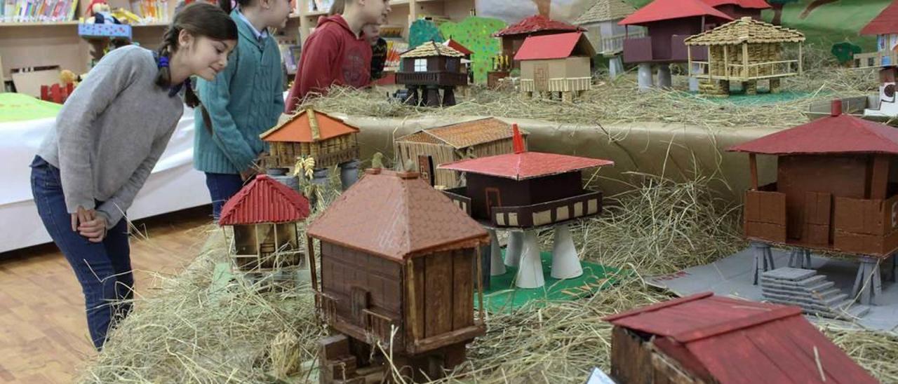 Por la izquierda, Sara Alonso, Lucía Cabrera, David Fernández y Pedro Fernández, ayer, ante la exposición de hórreos hechos a base de material reciclado, en la biblioteca del colegio de La Vallina de Luanco.