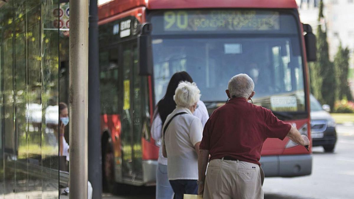 Tres usuarios esperan
al autobús en la parada
durante la segunda ola
de la pandemia.  fernando bustamante