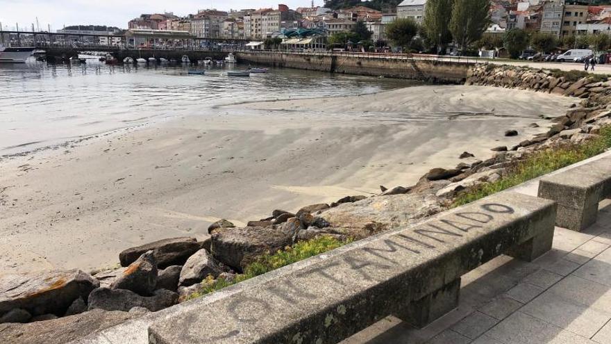 Pintadas en los bancos del paseo marítimo alertando de contaminación en la playa de O Señal