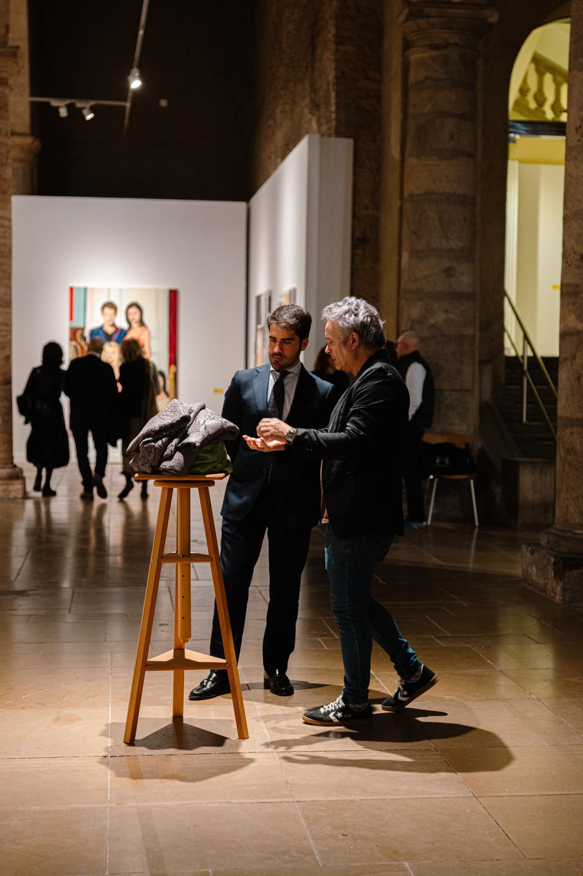 El concejal de Cultura de Murcia, Diego Avilés, admira una escultura junto al comisario de la exposición y director de la galería T20, Nacho Ruiz en la inauguración de la exposición este viernes.