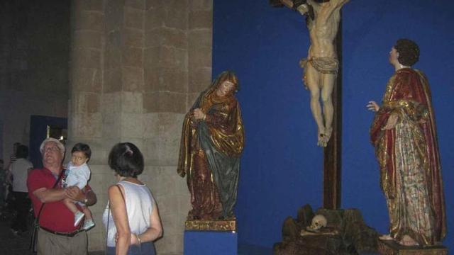 Visitantes admiran las obras de arte que se exponen en el interior de la Colegiata.