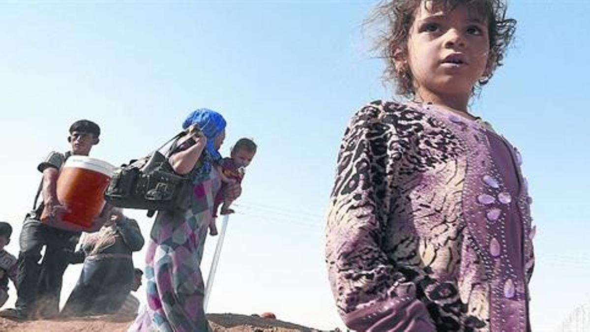 Una niña junto a un grupo de desplazados de Mosul, en Erbil.