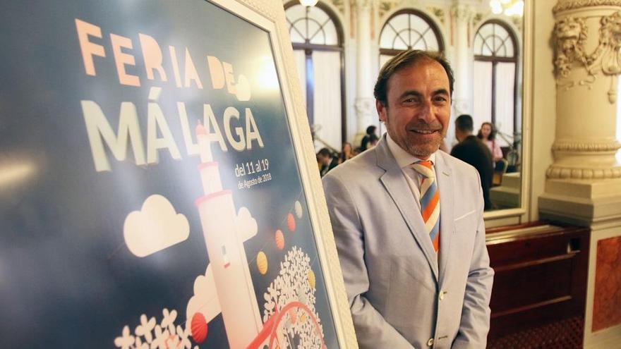 Andrés Olivares posa junto al cartel de la Feria de Málaga de 2018.