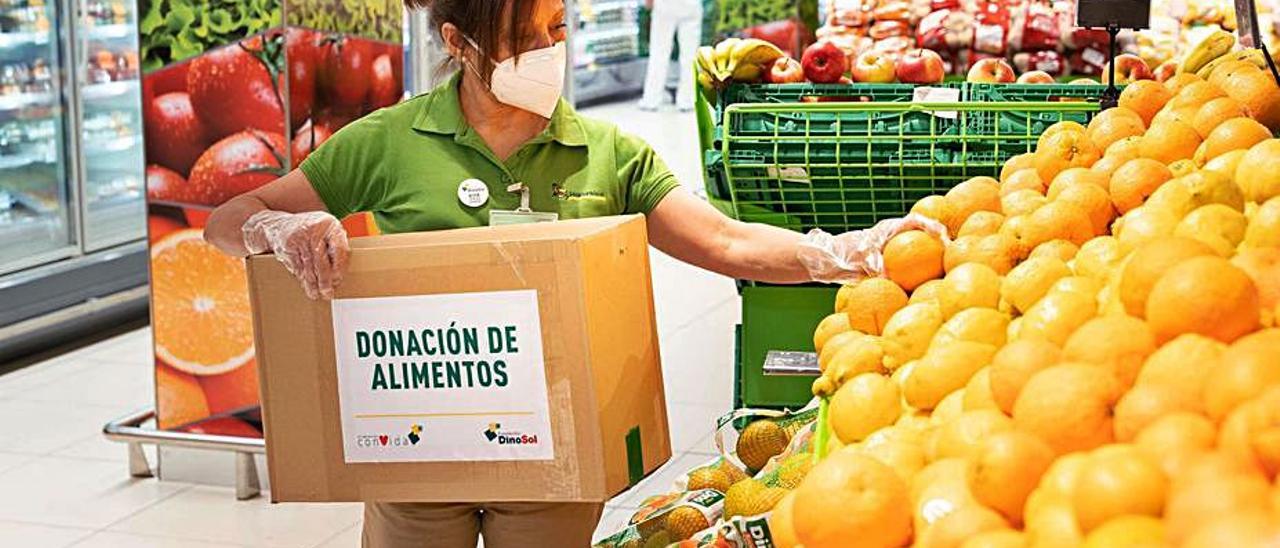 Una trabajadora de Hiperdino preparando una caja de donación de alimentos | | LP/DLP