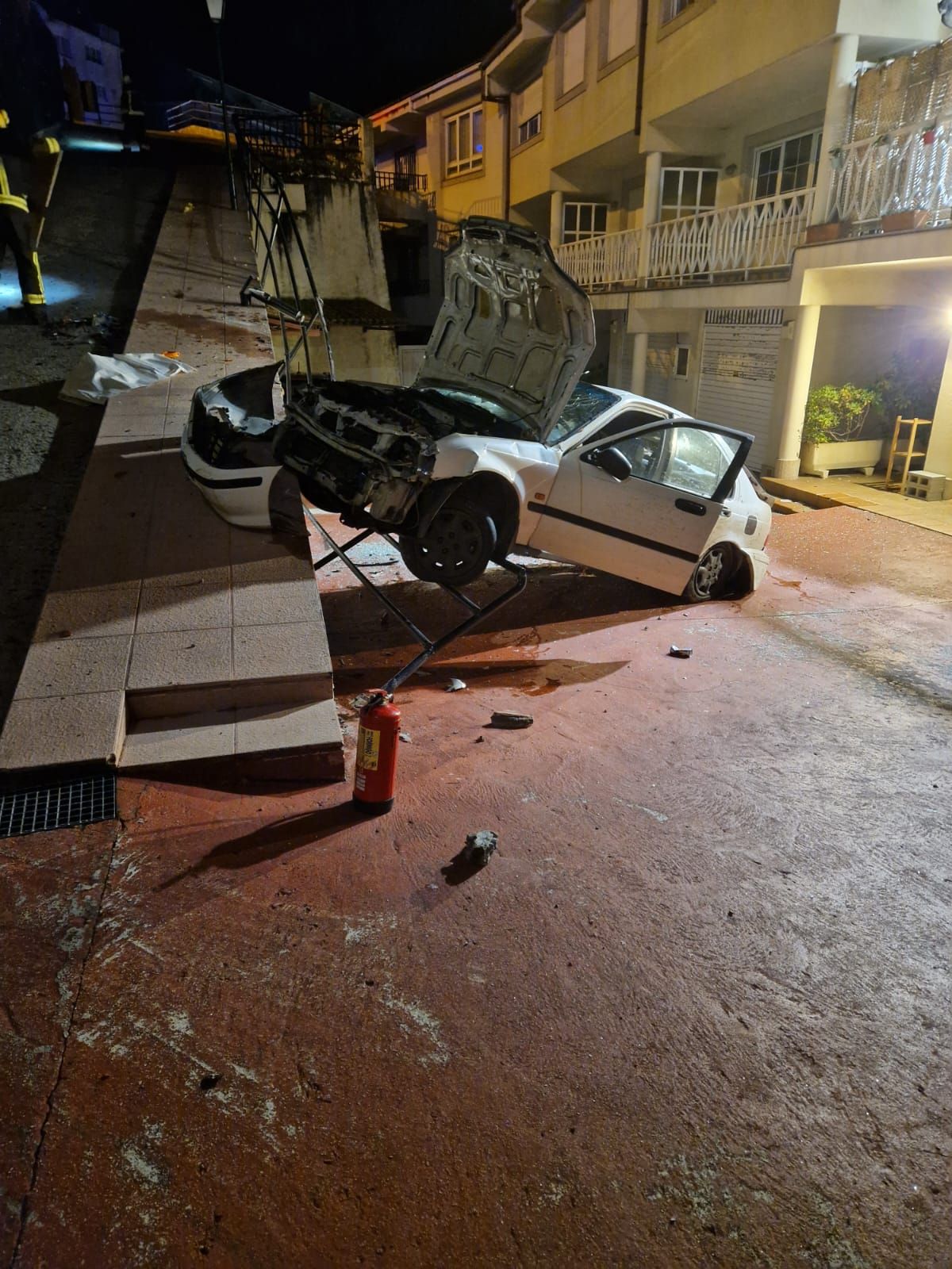 El coche, tras precipitarse al patio de unas viviendas en República Arxentina