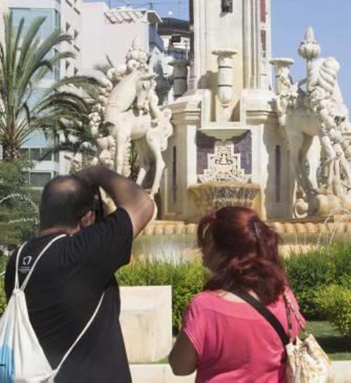Dos turistas ante la fuente de Luceros, cuya protección se aumentará para las mascletàs.