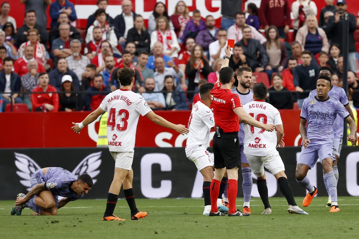 SEVILLA, 27/05/2023.- Marcos Acuña (2d, de espaldas), del Sevilla, ve tarjeta roja tras una jugada con Dani Ceballos (i), del Real Madrid, durante el partido de la jornada 37 de LaLiga disputado este sábado en el estadio Sánchez Pizjuán. EFE/Julio Muñoz