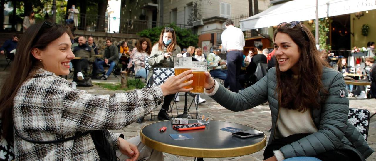 Dos jóvenes consumen en una terraza en París.