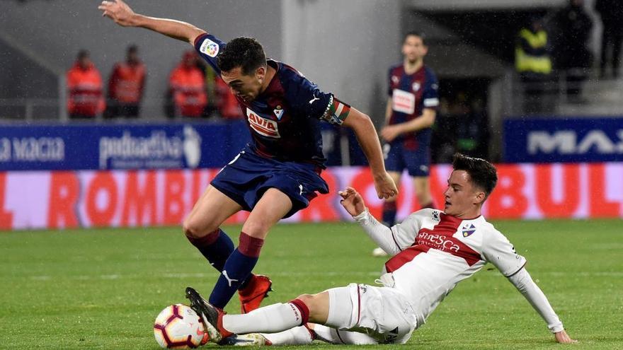 El centrocampista del Eibar Gonzalo Escalante (i) disputa el balón con el centrocampista del Huesca Juan Pablo Añor &quot;Juanpi&quot; (d). //Javier Blasco