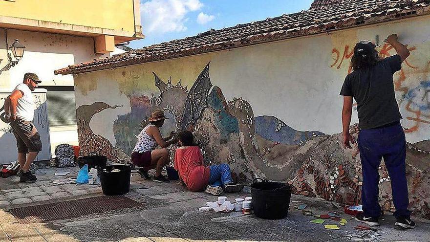 Unos artistas durante las labores de restauración del antiguo mural de la Coca de Redondela.