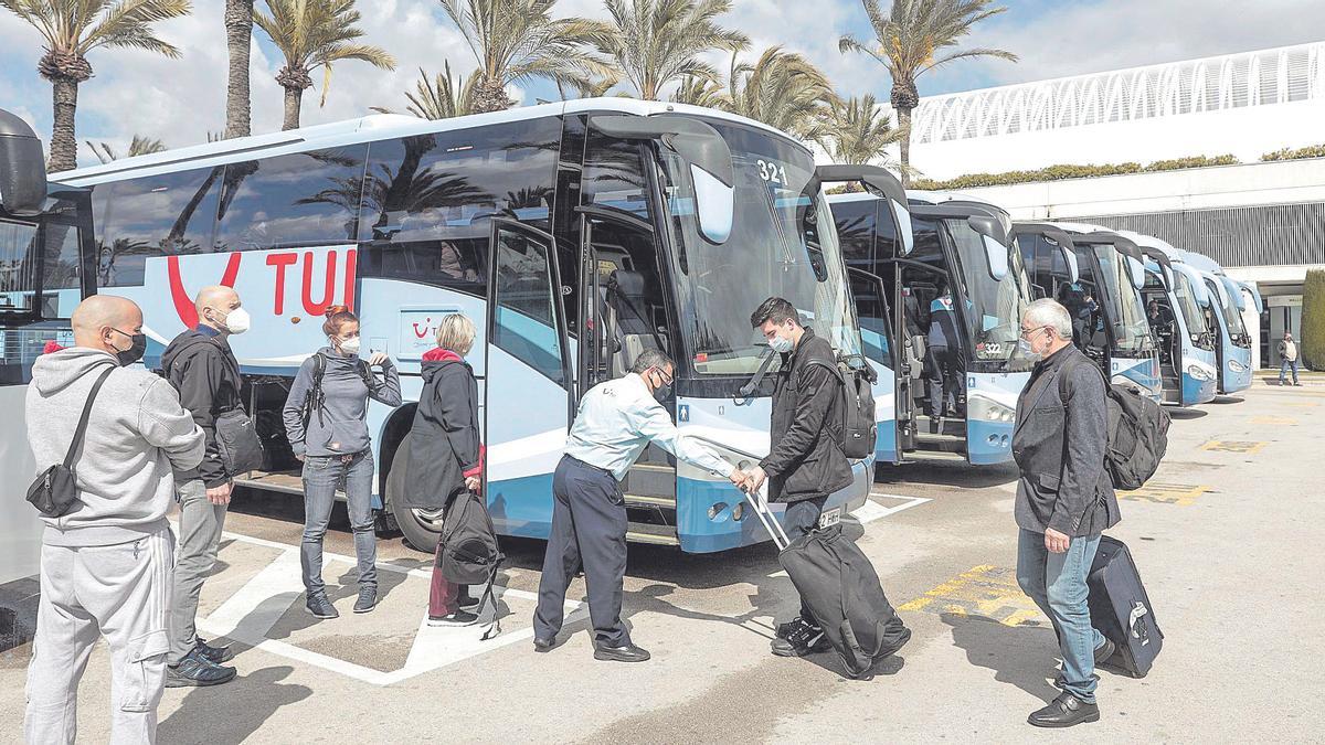 Turistas alemanse subiendo a los autobuses para ir a sus hoteles.