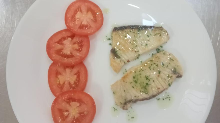 Proceso de elaboración de un plato de caella con tomates frescos.