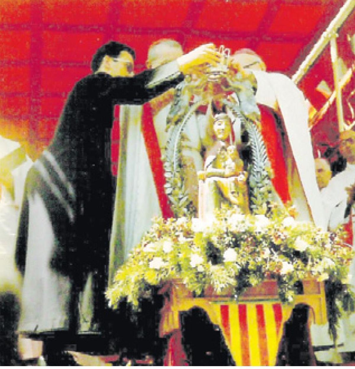 Mossèn Enric Lahoz col·locant bé la corona a la verge en la cerimònia de coronació canònica.
