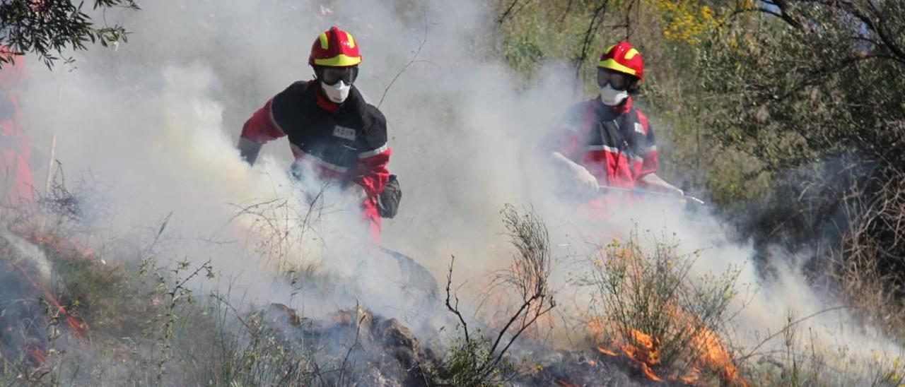 Voluntarios de la Asociación Contra Incendios Forestales (ACIF) de Alcoy colaborando en la extinción de un fuego.