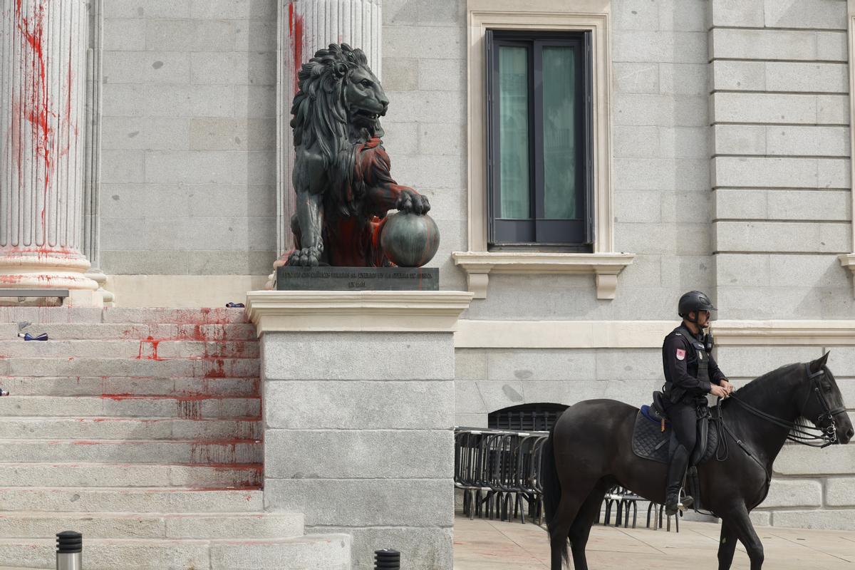 Uno de los leones del Congreso, cubierto con pintura roja después de una acción reivindicativa de Rebelión Científica este jueves en Madrid. EFE/ J.J. Guillén