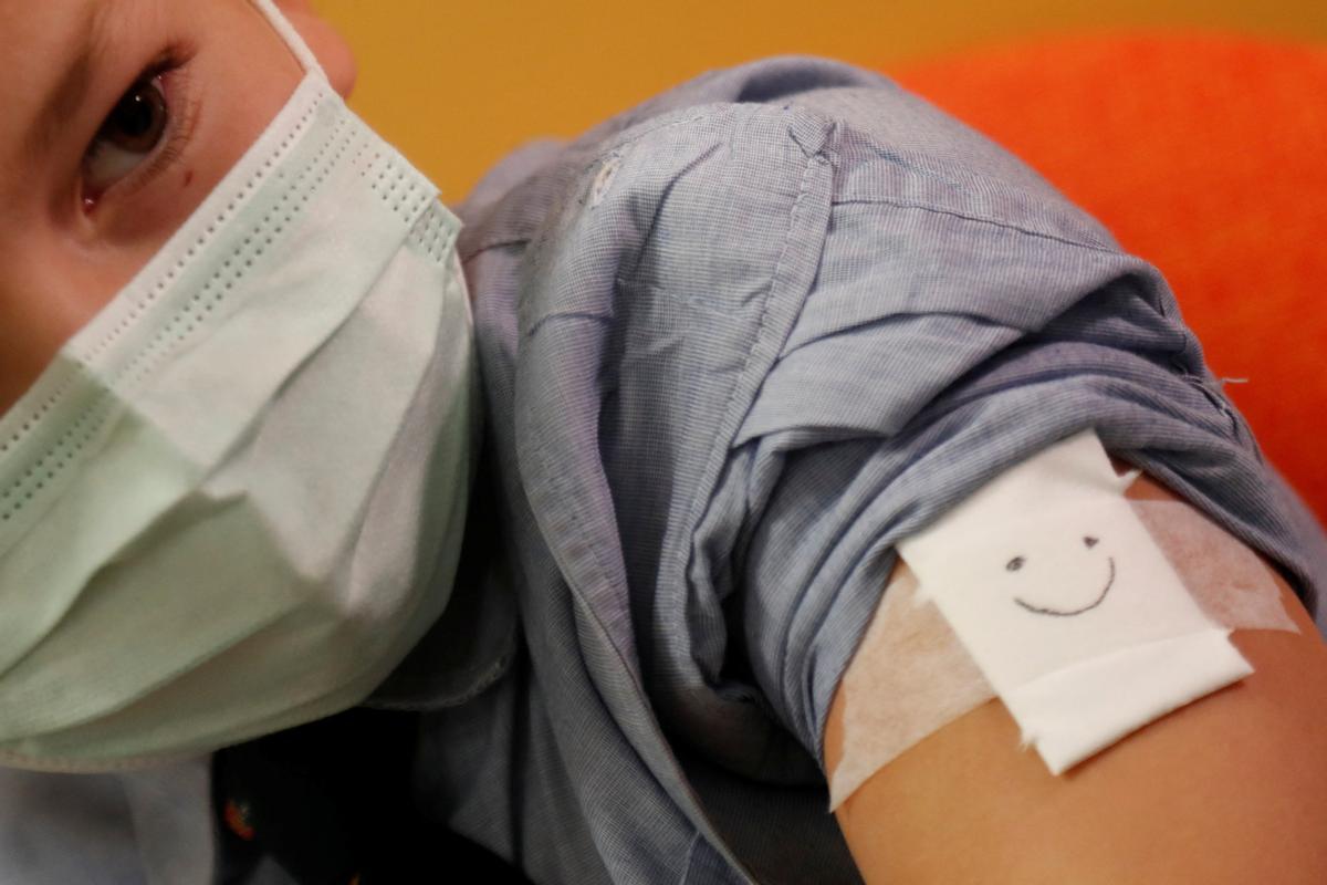 Pablo, de 9 años, recibe una carita sonriente tras vacunarse contra el covid en el Hospital Universitario Infanta Sofia de San Sebastián de los Reyes.