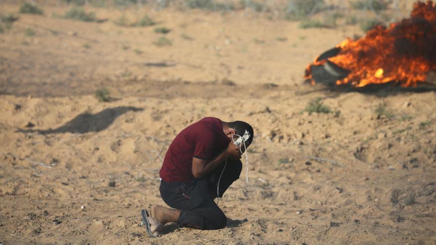 Un palestino se cubre durante un ataque en Gaza.