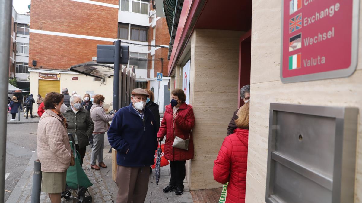 Usuarios mayores en la puerta de una entidad bancaria en Córdoba.