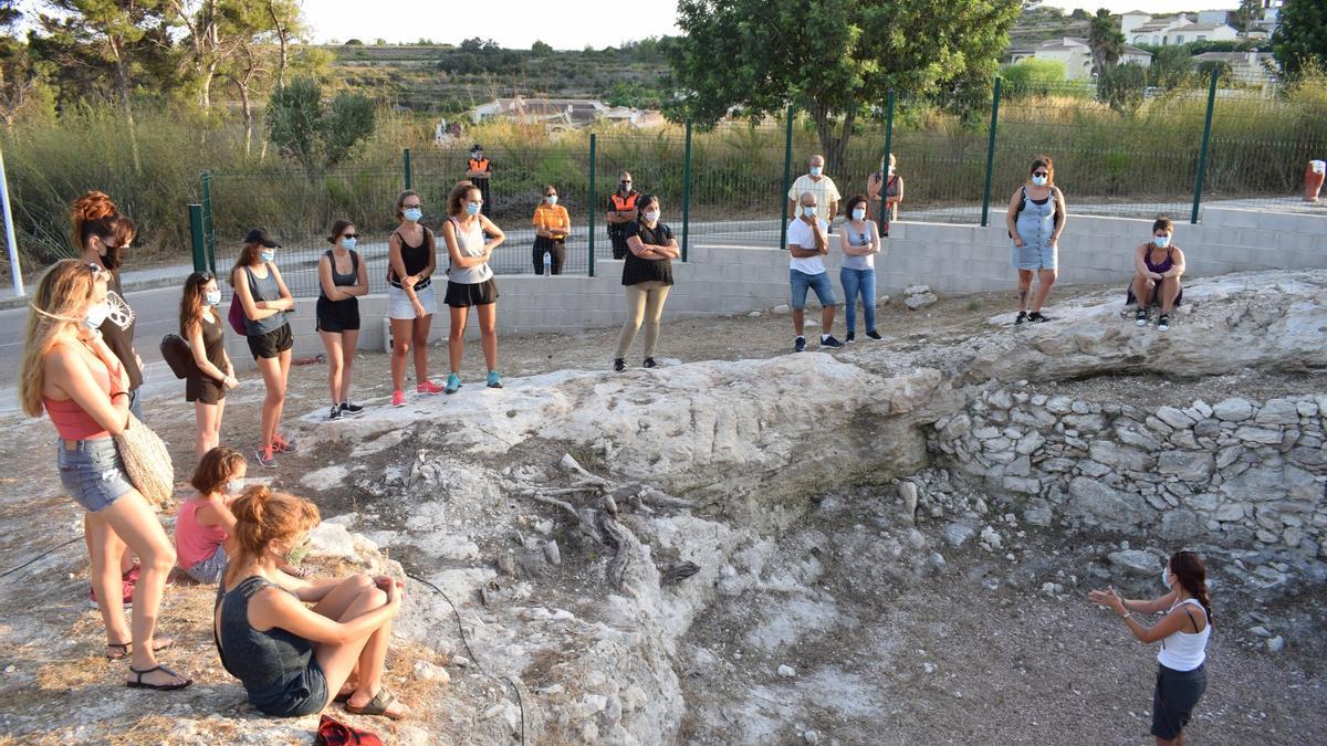 Una guía explica la historia de la Cova de les Bruixes.