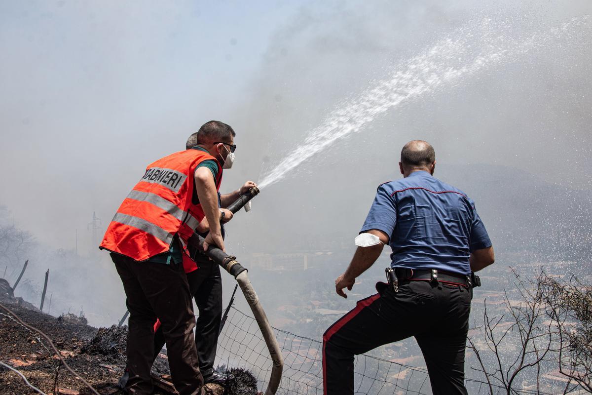 Palermo (Italy), 25/07/2023.- Police officers help locals put out a wildfire approaching houses in Palermo, Sicily, southern Italy, 25 July 2023. Wildfires have swept across Sicily amid Italy’s latest heatwave and Palermo airport was briefly closed to traffic in the morning of 25 July. (incendio forestal, Italia) EFE/EPA/Francesco Militello Mirto